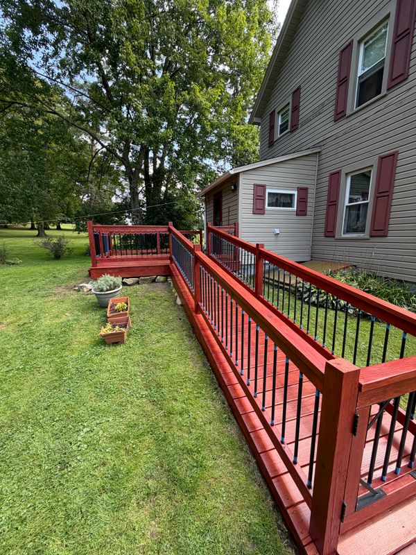 Long access ramp with red rails and dark spindles