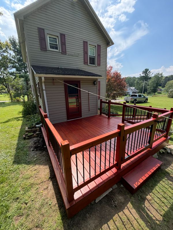 Rear deck and railings beside a two-story home