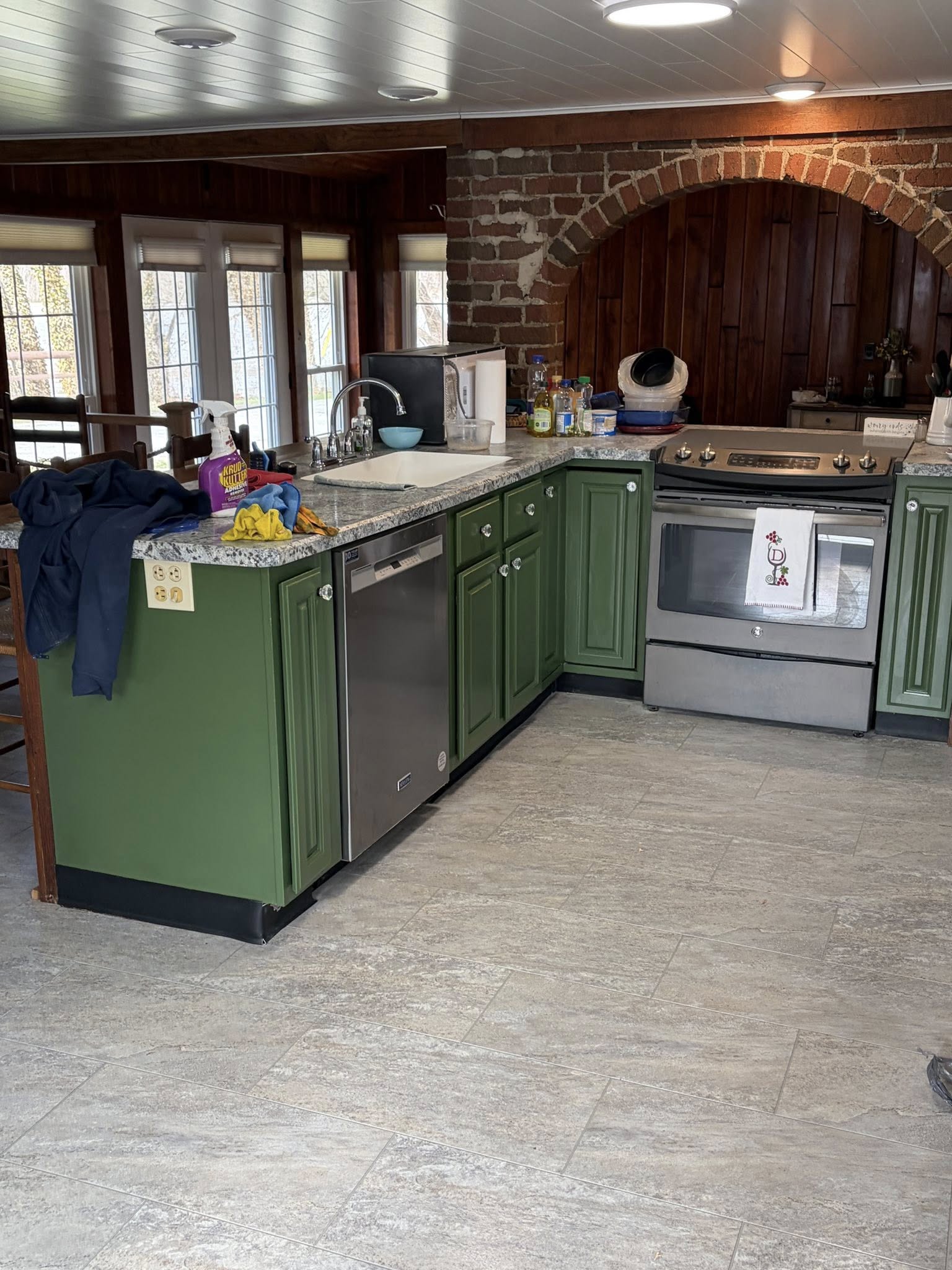 Green kitchen cabinetry and island refinished by Next Level Finishes