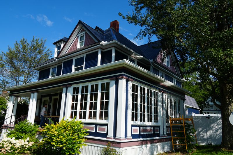 Painted Victorian porch, columns, window trim, and gables in Kane
